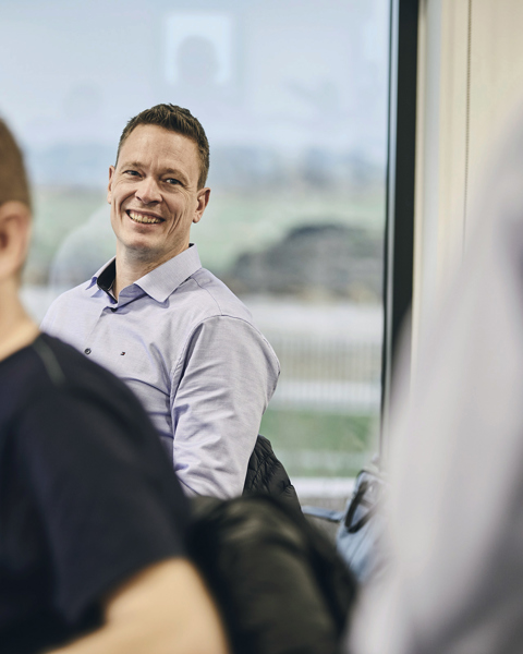 Two men smiling and working on computers at Danoffice IT.