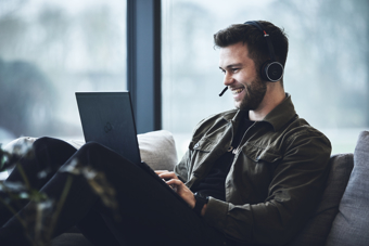 Person, der arbejder eksternt med en bærbar computer og headset, der repræsenterer en digital arbejdspladsløsning