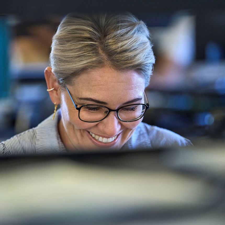 Smiling woman working at a computer in the Danoffice IT office.