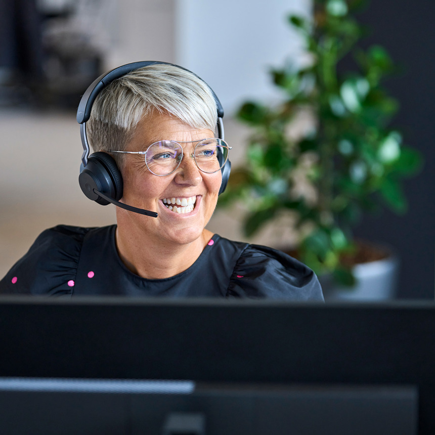 Smilende kundeservicemedarbejder med headset, vist ved siden af en kontakt formular til service bestillinger